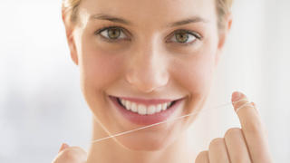 Frau verwendet Zahnseide Keine Weitergabe an Drittverwerter.