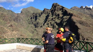 epa04998097 A picture made available 27 October 2015 shows firefighters at the Hell's Gorge in Tenerife, Canary Islands, Spain, 26 October 2015. A 62-year-old German tourist died in a landslide at Hell's Gorge as a group of 60 people were visiting. EPA/CRISTOBAL GARCIA
