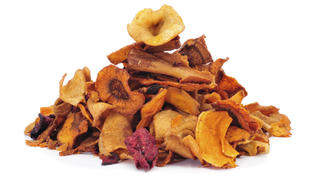 a pile of different vegetable chips, such as parsnips, sweet potatoes and carrots, on a white background