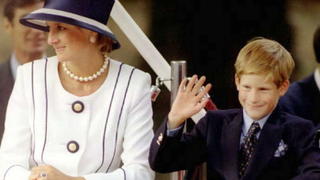 Princess Diana(L) and her son Harry(R) watch veterans as they march past a dais on the Mall as part of the commemorations of VJ Day 19 August. The commemoration  was held outside Buckingham Palace and was attended by 15,000 veterans and tens-of-thousands of spectators. AFP PHOTO (Photo credit should read ALLAN LEWIS/AFP/Getty Images)