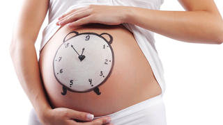 Conceptual image of pregnant belly with painted clock, Begriffsimage des schwangeren Bauchs mit der gemalten Uhr Keine Weitergabe an Drittverwerter.