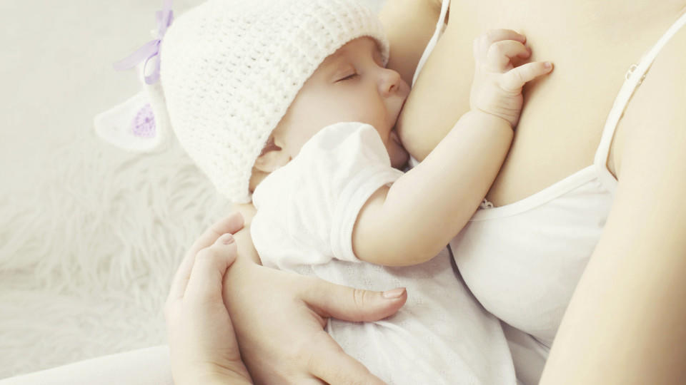 Soft photo mother feeding breast her baby at home 