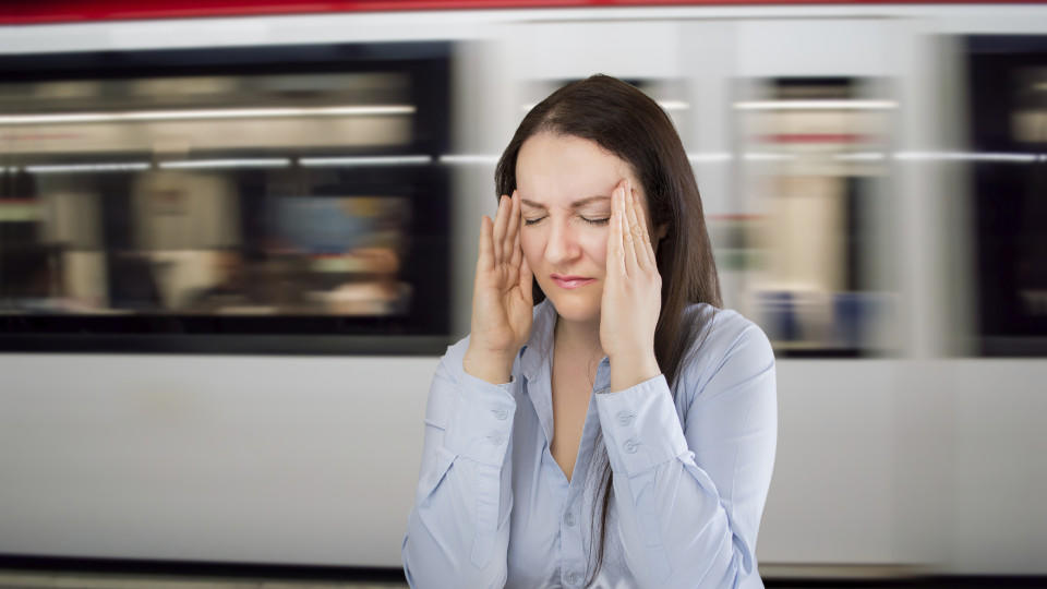 woman with headache at the underground station