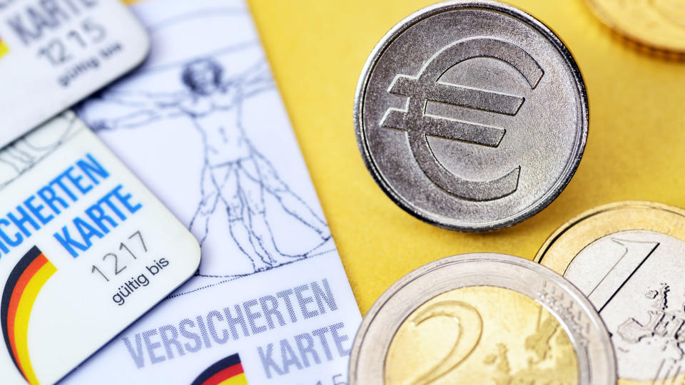 Krankenversichertenkarten und Münze mit Eurozeichen