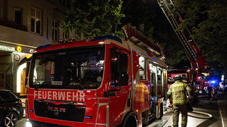 Feuerwehrwagen stehen am 01.07.2015 in Berlin auf der Sonnenallee in Neukölln vor einem Pflegezentrum. In dem mehrstöckigen Haus war am späten Abend des 30.06.2015 ein Feuer im Dachstuhl ausgebrochen. Bei dem Brand ist ein Mensch gestorben. Foto: Paul Zinken/dpa +++(c) dpa - Bildfunk+++