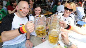Fußballfans freuen sich am Sonntag (27.06.2010) in München (Oberbayern) in einem Biergarten auf die Begegnung der Fußball-Weltmeisterschaft zwischen Deutschland und England. Bei hochsommerlichen Wetter werden an vielen öffentlichen Plätzen, in Biergä