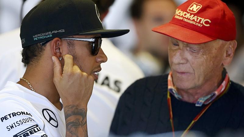 Mercedes Formula One driver Lewis Hamilton of Britain (L) speaks to former Formula One driver Niki Lauda of Austria during the first practice session of the Australian F1 Grand Prix at the Albert Park circuit in Melbourne March 14, 2014. REUTERS/Bran