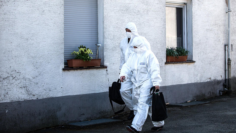 Mitarbeiter der Spurensicherung gehen am 02.05.2016 in Höxter (Nordrhein-Westfalen) am Haus des beschuldigten Ehepaares vorbei. Das mutmaßlich für den Tod einer 41-Jährigen verantwortliche Paar aus Höxter soll ein weiteres Tötungsdelikt gestanden hab