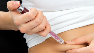 Insulin dependent Diabetes patient make a subcutaneous injection by single use syringe with needle and  insulin into abdomen by doctor prescription 