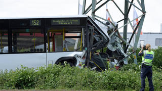 Ein Linienbus hat sich am 15.05.2016 in Köln (Nordrhein-Westfalen) in einen Hochspannungsmast verkeilt. Nach ersten Informationen der Polizei konnte der Busfahrer wegen starker Übelkeit oder Ohnmacht das Fahrzeug nicht mehr unter Kontrolle halten. Er ist dann mit dem Bus von der Fahrbahn abgekommen und gegen den Mast gefahren. Foto: Caroline Seidel/dpa   (zu dpa "Linienbus verunglückt - 19 Menschen verletzt" vom 15.05.2016) +++(c) dpa - Bildfunk+++