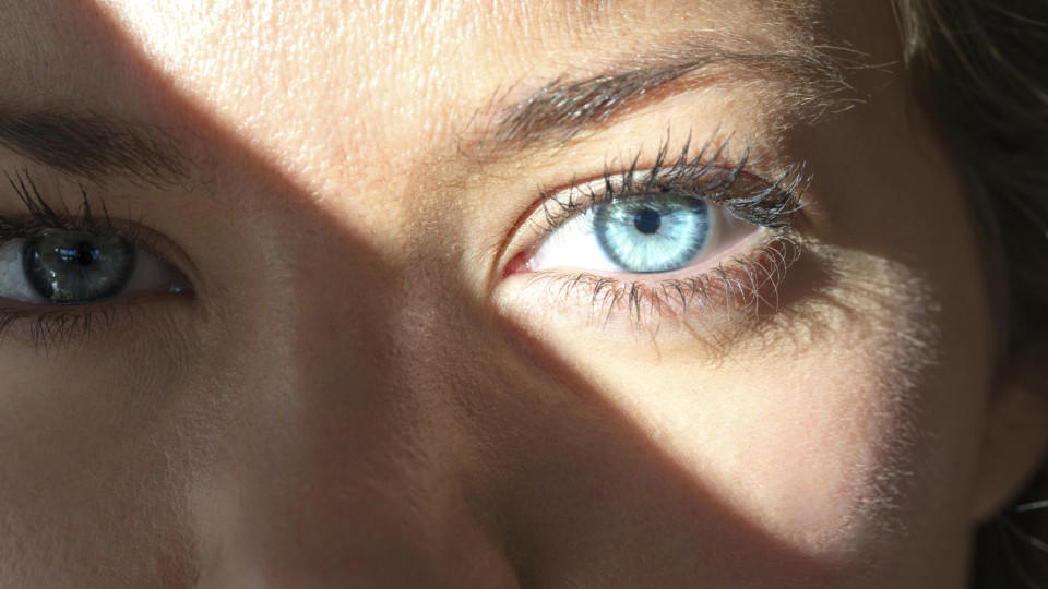 Eine junge Frau mit blauen Augen schaut in die Sonne.