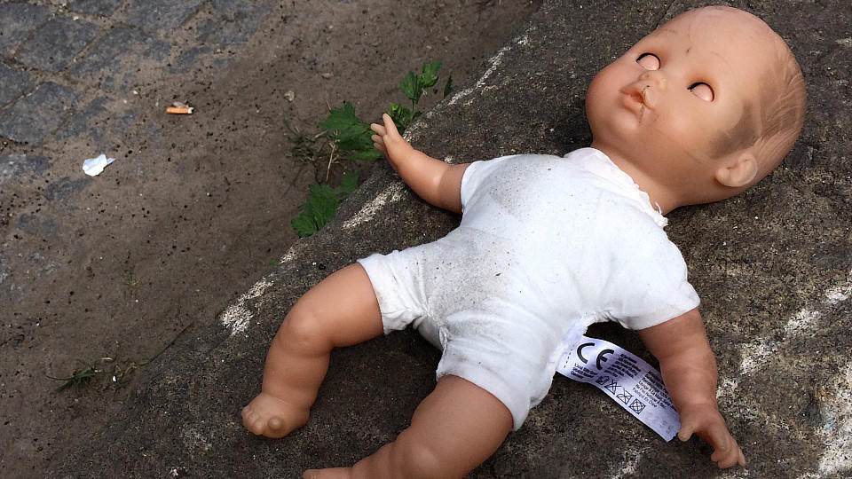 ARCHIV - ILLUSTRATION - Eine Puppe liegt am 30.04.2014 in Berlin am Straßenrand. Eine Mutter soll ihre eigenen Kinder zum sexuellen Missbrauch an Freier verkauft haben. Vor dem Hamburger Landgericht beginnt am 19.05.2016 der Prozess gegen die 52-Jähr