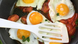 Sunny side up eggs in pan - outdoor breakfast on grass