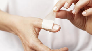 Forefinger of a woman hand with a band aid