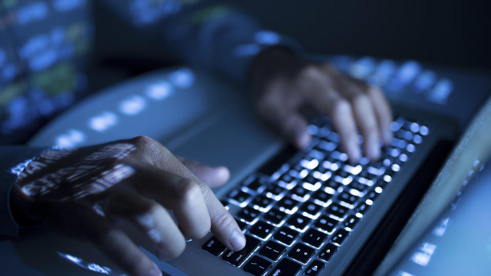 Close-up image of coder typing on computer