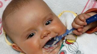 Das sieben Monate alte Baby Amira aus dem brandenburgischen Sieversdorf knabbert an einen Löffel und hat sich den Mund mit Brei verschmiert, aufgenommen am 08.05.2007. Foto: Patrick Pleul +++(c) dpa - Report+++