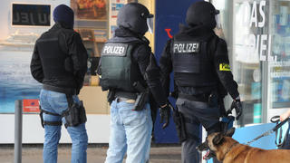 Einsatzkräfte der Polizei warten am 07.08.2016 in der Nähe des Rathauses in Saarbrücken (Saarland) auf ihren Einsatz. In der Innenstadt hat sich der Polizei zufolge ein Bewaffneter in einem Lokal verschanzt. Foto: Becker&Bredel/dpa +++(c) dpa - Bildfunk+++