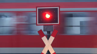 ARCHIV - Ein Regionalexpress der Bahn fährt am 10.12.2008 an einem Bahnübergang bei Ebenhofen hinter einem rot leuchtenden Signal vorbei. Die Deutsche Bahn gibt am Donnerstag (28.07.2011) eine Pressekonferenz zur Halbjahresbilanz. Foto: Karl-Josef Hi