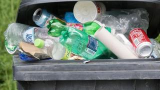 Plastikflaschen liegen in einer überfüllten Mülltonne. Foto: Armin Weigel