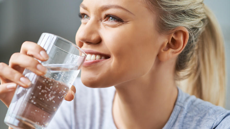 Beautiful young woman drinking water