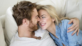 Loving couple relaxing at home lying on the sofa - relationship concepts 
