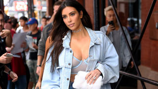 TV personality Kim Kardashian, wearing clear, plastic knee-length boots, jean shorts and jean jacket, leaves the Mercer Hotel in New York City
