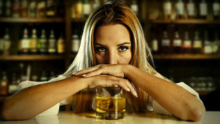 drunk woman alone in wasted and depressed face expression leaning on  scotch whiskey glass isolated at bar or pub in alcohol abuse and alcoholic housewife concept