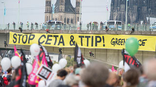 Aktivisten von Greanpeace bringen ein Banner an der Deutzer Brücke an am 17.09.2016, bei einer Demonstration gegen die Handelsabkommen Ceta und TTIP in Köln (Nordrhein-Westfalen). Zehntausende Menschen werden in vielen deutschen Großstädten zu Kundgebungen gegen die Handelsabkommen TTIP und Ceta erwartet. Aufgerufen zu den Kundgebungen hat ein Bündnis aus 26 Gewerkschaften, Umweltverbänden und kirchlichen Gruppen. Foto: Wolfram Kastl/dpa +++(c) dpa - Bildfunk+++