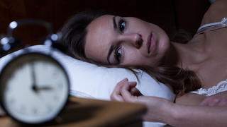 Woman lying in bed suffering from insomnia