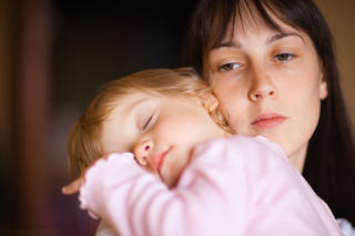 Sleepy little child with mom - shallow DOF, focus on woman\'s eyes