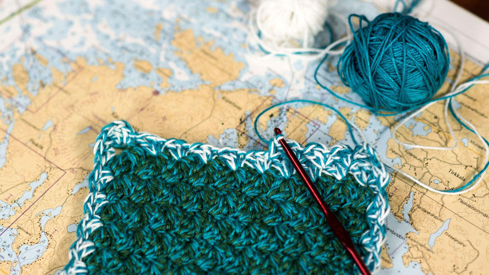 Häkelarbeit mit Häkelnadel und Wollknäuel