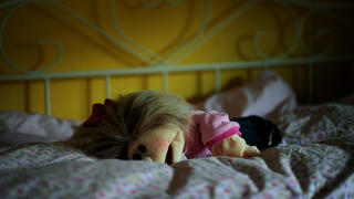 ARCHIV - SYMBOLFOTO - Eine Puppe liegt am 13.05.2011 in Kassel in einem Kinderzimmer auf dem Bett. (zu dpa «Schutz von Kindern vor sexueller Gewalt: Bund fördert Forschung» vom 29.11.2016) Foto: Uwe Zucchi/dpa +++(c) dpa - Bildfunk+++