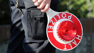 ARCHIV - Ein Polizeibeamter hält am 18.09.2014 bei einer Geschwindigkeitskontrolle in Gokel (Schleswig-Holstein) eine Polizeikelle. Schleswig-Holsteins Landespolizei kontrolliert in der nächsten Woche Autofahrer gezielt auf Alkohol und Drogen. Die von Montag bis Sonntag laufende Aktion sei europaweit abgestimmt, erklärte das Landespolizeiamt. (zu dpa «Polizei geht ab Montag Alkohol- und Drogensündern auf die Spur» vom 12.12.2016) +++(c) dpa - Bildfunk+++