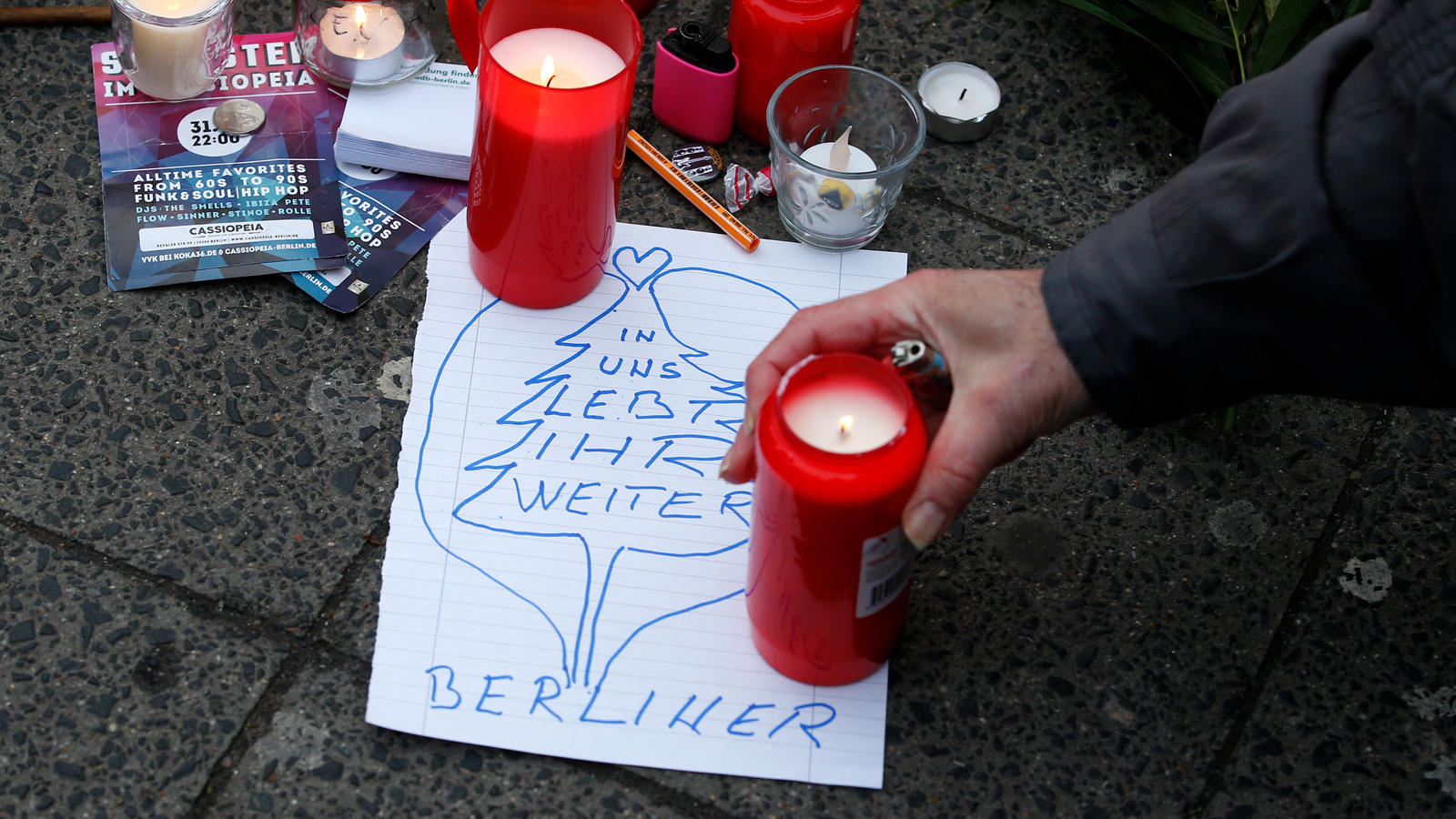 Auf dem Weihnachtsmarkt in Berlin legen Menschen Kerzen, Bilder und Blumen ab, um der Opfer zu gedenken.