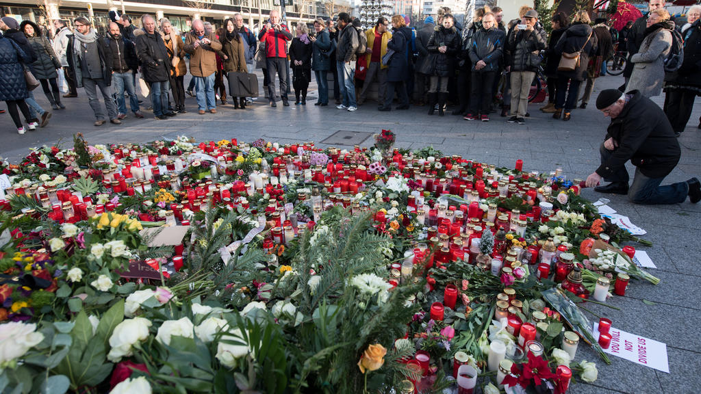 Trauernde legen am 21.12.2016 am Anschlagsort auf dem Weihnachtsmarkt am Breitscheidplatz in Berlin Blumen nieder und zünden Kerzen an. Bei dem Anschlag mit einem Lastwagen auf den Weihnachtsmarkt an der Gedächtniskirche am Montagabend (19.12.2016) i