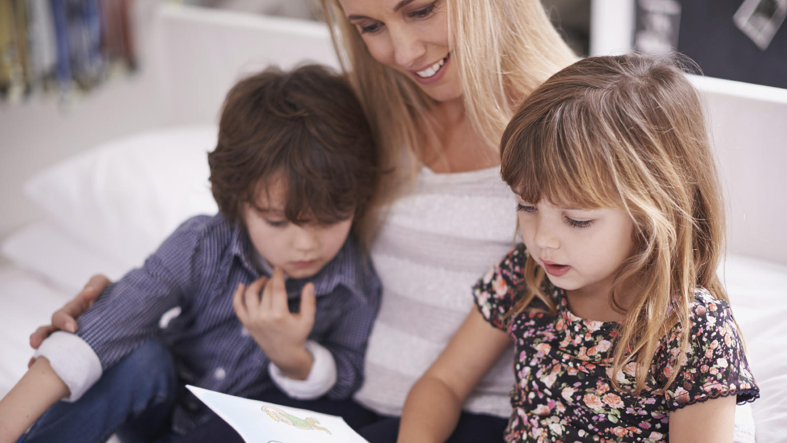 Shot of a mother reading with her children at home