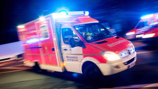 ILLUSTRATION - Ein Rettungswagen der Feuerwehr fährt am 17.10.2015 in Recklinghausen (Nordrhein-Westfalen) mit Blaulicht durch eine Straße (Aufnahme mit langer Belichtungszeit). Während eines Rettungseinsatzes in Essen sind am späten Dienstagabend ein Notfallkoffer und ein Rucksack mit Beatmungsgerät und Medikamenten aus einem Krankenwagen gestohlen worden. Wie die Feuerwehr Essen am Mittwoch mitteilte, nutzten der oder die unbekannten Täter die Zeit, in der Notarzt und Sanitäter den Patienten versorgten. Die Türen des Wagens waren - wie bei einem Notfalleinsatz üblich - nicht verschlossen. Der Koffer wurde später ohne Inhalt von der Polizei gefunden. Der Sachschaden beträgt etwa 2500 Euro. Foto: Marcel Kusch/dpa +++(c) dpa - Bildfunk+++