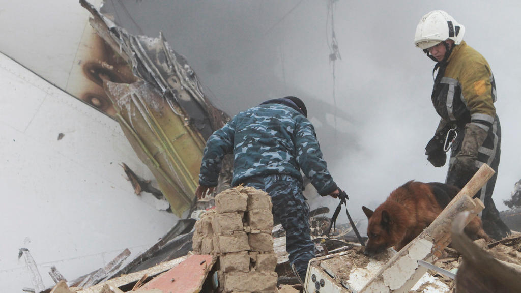 Members of a rescue team work at the crash site of a Turkish cargo jet near Manas airport outside the capital city Bishkek, Kyrgyzstan, January 16, 2017. REUTERS/Vladimir Pirogov