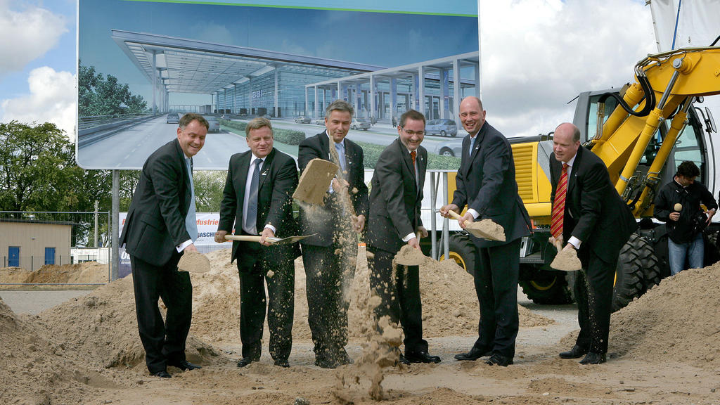 ARCHIV - Mit einem symbolischen Spatenstich nahe dem Flughafen Berlin-Schönefeld bei Berlin geben am 05.09.2006 (l-r) der damalige Sprecher der Geschäftsführung des BBI Rainer Schwarz, der damalige Bahn-Chef Hartmut Mehdorn, Berlins damaliger Regiere