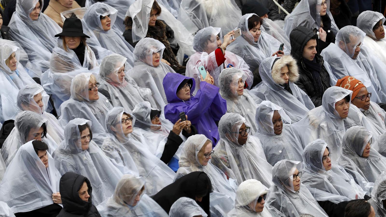Spectators protect themselves from the rain during the inauguration ceremonies to swear in Donald Trump as the 45th president of the United States at the U.S. Capitol in Washington, U.S., January 20, 2017. REUTERS/Kevin Lamarque