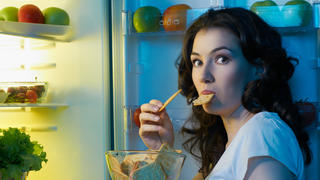 a hungry girl opens the fridge