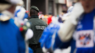 ARCHIV - Ein Polizist sichert am 16.02.2015 den Rosenmontagszug in Köln (Nordrhein-Westfalen). Stadt, Polizei und Festkomitee stellen in Köln die geplanten Sicherheitsvorkehrungen für den Straßenkarneval vor. Foto: Rolf Vennenbernd/dpa +++(c) dpa - Bildfunk+++