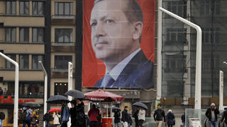 Passanten gehen am 14.03.2017 auf dem Taksim-Platz in Istanbul, Türkei, an einem riesigen Poster des türkischen Ministerpräsidenten Recep Tayyip Erdogan vorbei. Ungeachtet aller Appelle zur Deeskalation hat  Erdogan am 14.03. den Niederlanden «Staatsterrorismus» und eine «neonazistische Gesinnung» vorgeworfen. Foto: Lefteris Pitarakis/AP/dpa +++(c) dpa - Bildfunk+++
