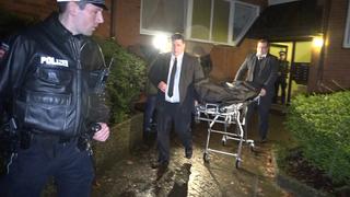 Mitarbeiter eines Bestattungsunternehmens sowie ein Polizist (l) bewegen sich am 20.03.2017 in Hamburg vor einem Mehrfamilienhaus. In einer Wohnung sind am Montagabend die Leichen eines Mannes und seines Sohnes entdeckt worden. Die Hintergründe waren zunächst unklar. Foto: CityNewsTV/dpa +++(c) dpa - Bildfunk+++