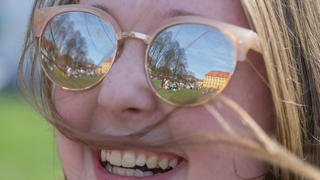Das Schloß spiegelt sich am 31.03.2017 im Schloßgarten in Osnabrück (Niedersachsen) in der Sonnenbrille einer Studentin. Auf über 25 Grad Celsius kletterte das Thermometer am bisher wärmsten Tag des Jahres in Niedersachsen. Foto: Friso Gentsch/dpa | Verwendung weltweit