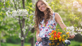 Beautiful women In the Fruit Garden at spring with bicycle