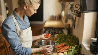 Cropped shot of a woman cutting carrots on a cutting board