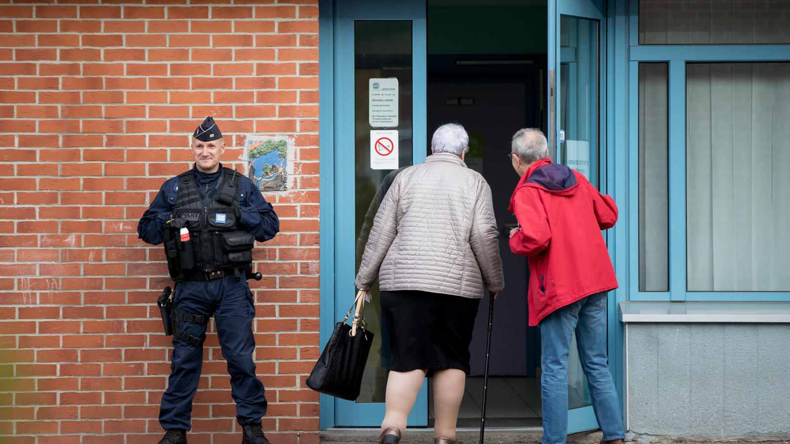 Wähler betreten am 23.04.2017 in Henin-Beaumont (Frankreich) das von der Polizei bewachte Wahllokal, in dem die Spitzenkandidatin der Front National, Le Pen, ihre Stimme für die Präsidentschaftswahl in Frankreich abgeben wird. In der ersten Runde tre