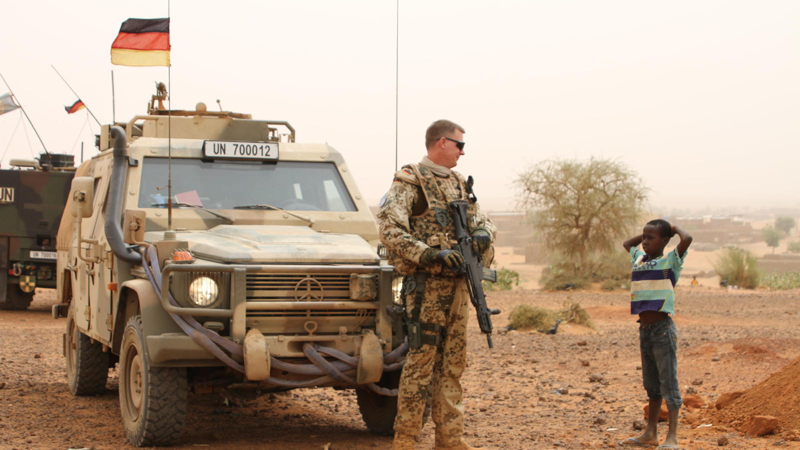 ARCHIV - Ein deutscher Blauhelmsoldat unterhält sich während einer Patrouille am 07.05.2016 in der Stadt Gao im Norden Malis mit einem Kind.    (zu dpa "Bericht: Extremes Klima in Mali legt Bundeswehr-Fahrzeuge lahm" vom 19.04.2017) Foto: Kristin Palitza/dpa +++(c) dpa - Bildfunk+++