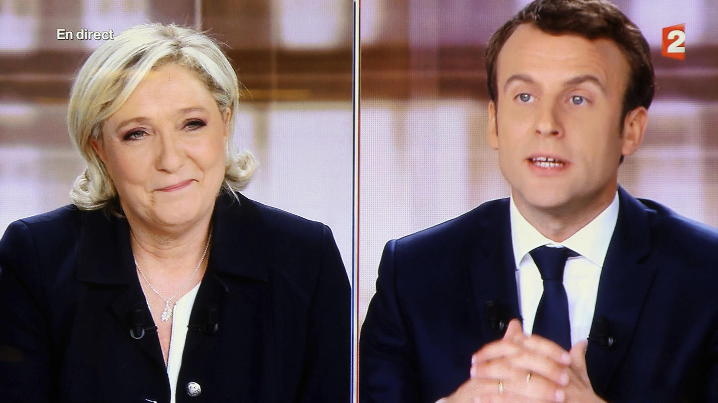 Die Rechtspopulistin und Kandidatin der Front National, Marine Le Pen, und ihr sozialliberaler Gegner Emmanuel Macron sprechen bei einer Live-TV-Debatte und sind dabei auf einem Bildschirm in einer Bar in Biarritz, Frankreich, am 03.05.2017 zu sehen.